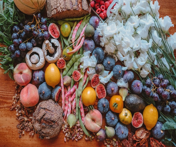 an assortment of fruits and vegtables on a wooden table.