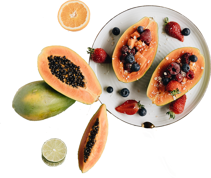 a papaya cut in half on display with assorted fruits around it as garnishing